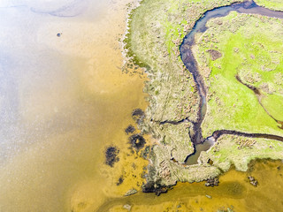 Aerial view of the Glaslyn Marshes close to the railway with the Snowdonia mountain range national park in background - Porthmadog, Wales - United Kingdom