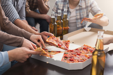 Hands of friends taking slices of tasty pizza at home