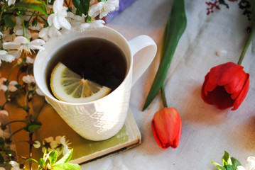 Tulips and a cup of tea on the table
