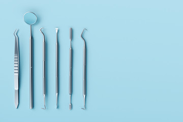 Dentist tools on pastel blue background.