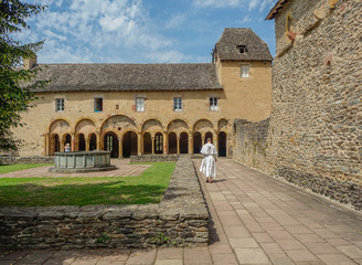 Conques, Midi Pyrenees, France - July 31, 2017: Fountain and arcade in the interior courtyard of the Conques monastery