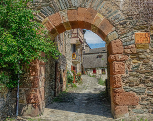 Conques, Midi Pyrenees, France - July 31, 2017: Old entrance arch to the medieval village of Conques in France