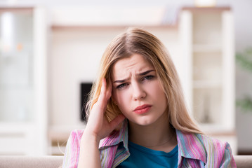 Fototapeta premium Young woman suffering with pain at home