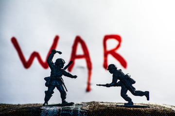 Plastic toy soldiers are on the table. In the background, the inscription 