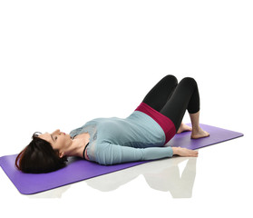 Mother woman exercising doing postnatal workout. Female fitness instructor holds legs in gym and...