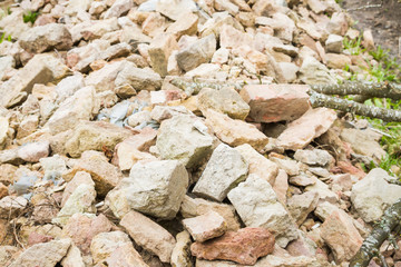 Stones and broken bricks lie in a pile on the street