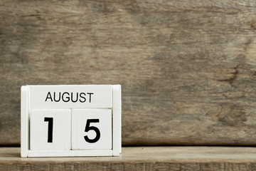 White block calendar present date 15 and month August on wood background