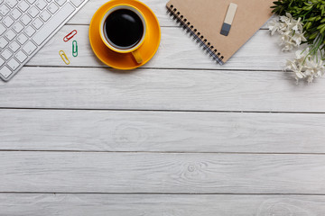 Office table with blank notepad and laptop