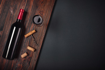 Bottle of wine corkscrew and wineglass on rusty background