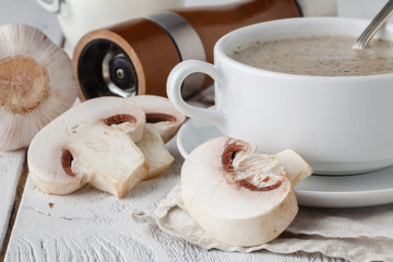 Fresh mashed mushroom soup with bread croutons and pepper on wooden background