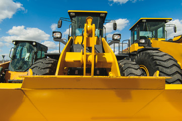 road-building machinery, tractors yellow excavators in the open air in working position