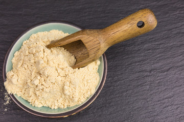 powdered maca root in a bowl with wooden scoop