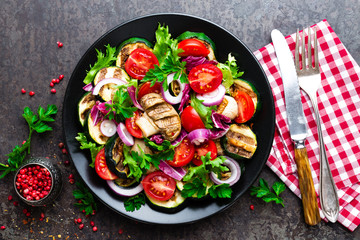 Salad with fresh and grilled vegetables and mushrooms. Vegetable salad with grilled champignons. Vegetable salad on plate. Healthy vegetarian food