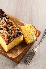 cake with almonds and blueberries on wooden cutting Board. top view