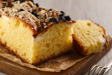 cake with almonds and blueberries on wooden cutting Board. Closeup