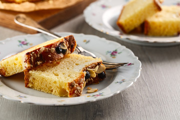 sliced cake with almonds and blueberries on a white ceramic plate