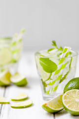 Summer refreshing cocktail mojito with lime and mint on white wooden vintage background.