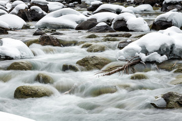 Wild Idaho river in winter with snow capped rocks and ice