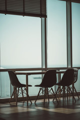 modern wooden table with dining chair near big window office background