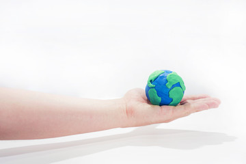 Small Earth model with human hands.