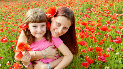 mother and daughter into a field of poppies