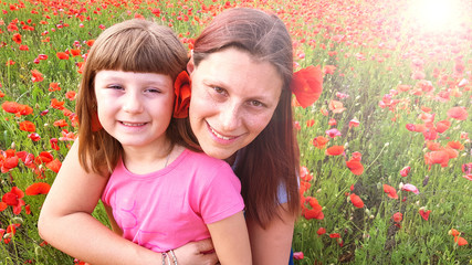 mother and daughter into a field of poppies