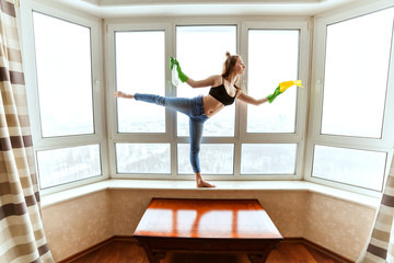 Woman dances while washing the windows in the apartment.