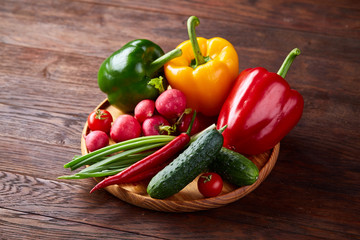 Composition of vegetables on flat plate on wooden table, close-up, selective focus