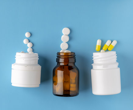 Various pills bottles and white round pills