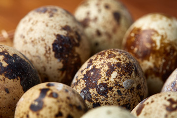 Group of three quail eggs on a wooden table, top view, close-up, selective focus, copy space.