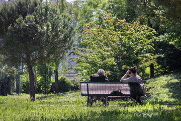old woman with caretaker, the couple sitting at the park
