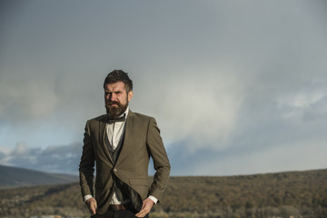 Bearded man on cloudy sky. Hipster with beard and mustache on unshaven face. Fashion businessman...
