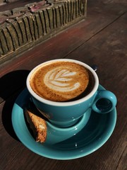Delicious cappuccino coffee in a blue mug 