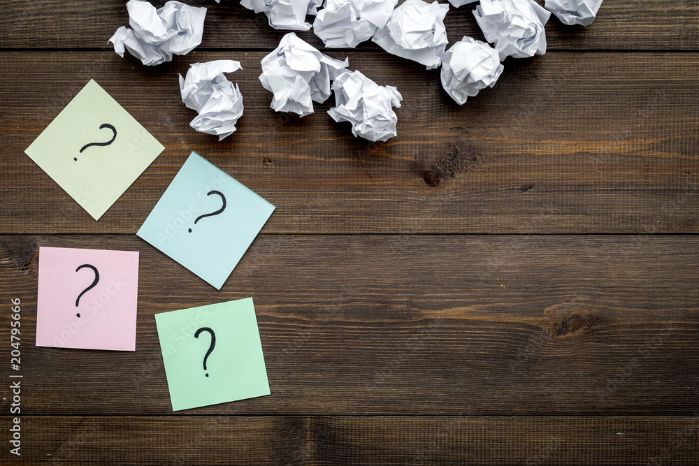 Poster faq concept. question mark on sticky notes near crumpled paper on dark wooden background top view co