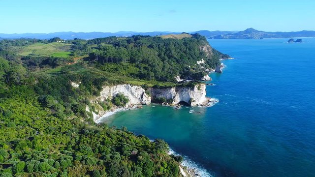 Aerial view of white cliffs and beaches of Cathedral Cove - South Pacific Ocean shore, Coromandel Peninsula, North Island, New Zealand from above, 4k UHD