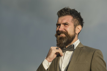 Hipster with beard and mustache on unshaven face. Hipster smiling on cloudy sky, copy space