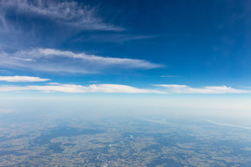 Fototapeta premium View from the airplane to the sky above the Alps mountains. Blue sky with clouds. Background.