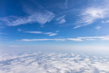 Fototapeta premium View from the airplane to the sky above the Alps mountains. Blue sky with clouds. Background.
