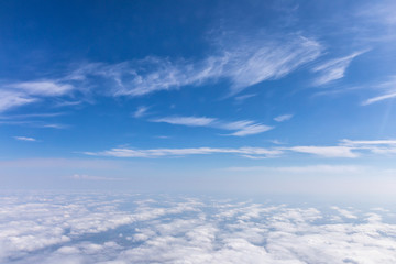 View from the airplane to the sky above the Alps mountains. Blue sky with clouds. Background.