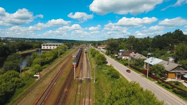 Passenger train on a railway in a rural country. Aerial view train, railway, highway. Aerial drone footage, 4k.