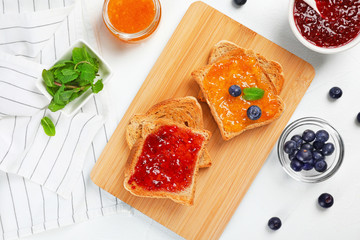 Toasts with sweet jam on light background, flat lay composition
