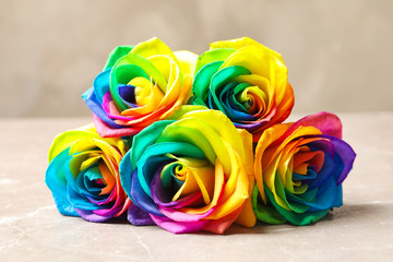 Fototapeta na wymiar Amazing rainbow rose flowers on table