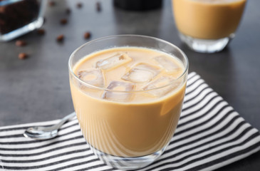 Glass with cold brew coffee and milk on table