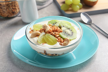 Bowl with yogurt, fruits and granola on table