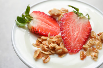 Bowl with tasty yogurt, strawberry and granola, closeup