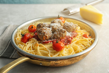 Pasta with meatballs and tomato sauce on table