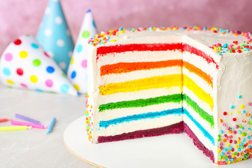 Delicious rainbow cake for party on table