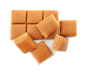 Delicious caramel candies on white background