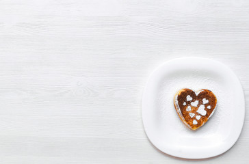 Freshly baked curd on the plate with powdered sugar on white wooden table background.