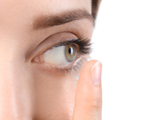 Fototapeta premium Young woman putting contact lens in her eye, closeup